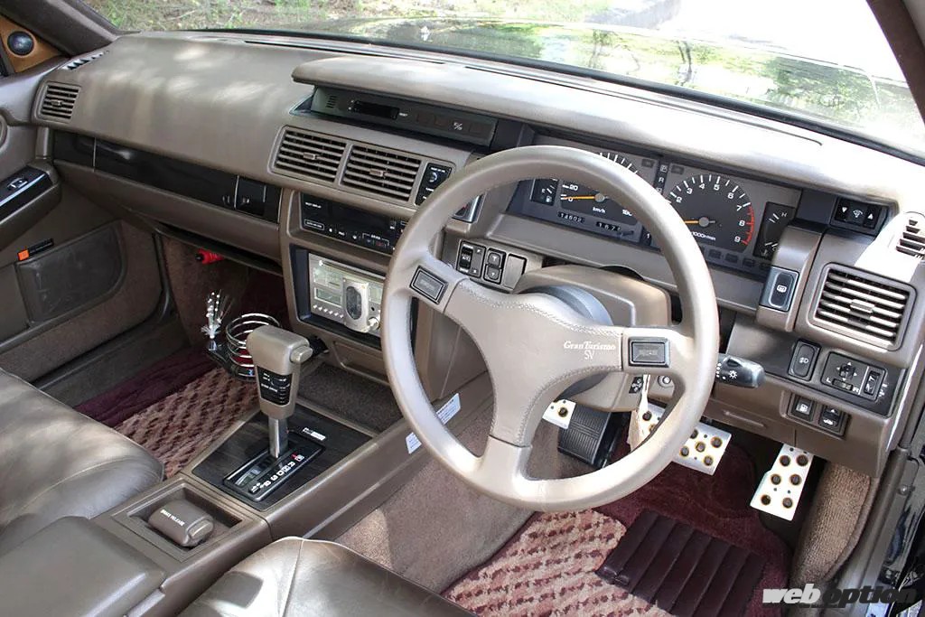 Interior of a Nissan Gloria Gran Turismo Super SV, showing steering wheel, dashboard, and gear selector